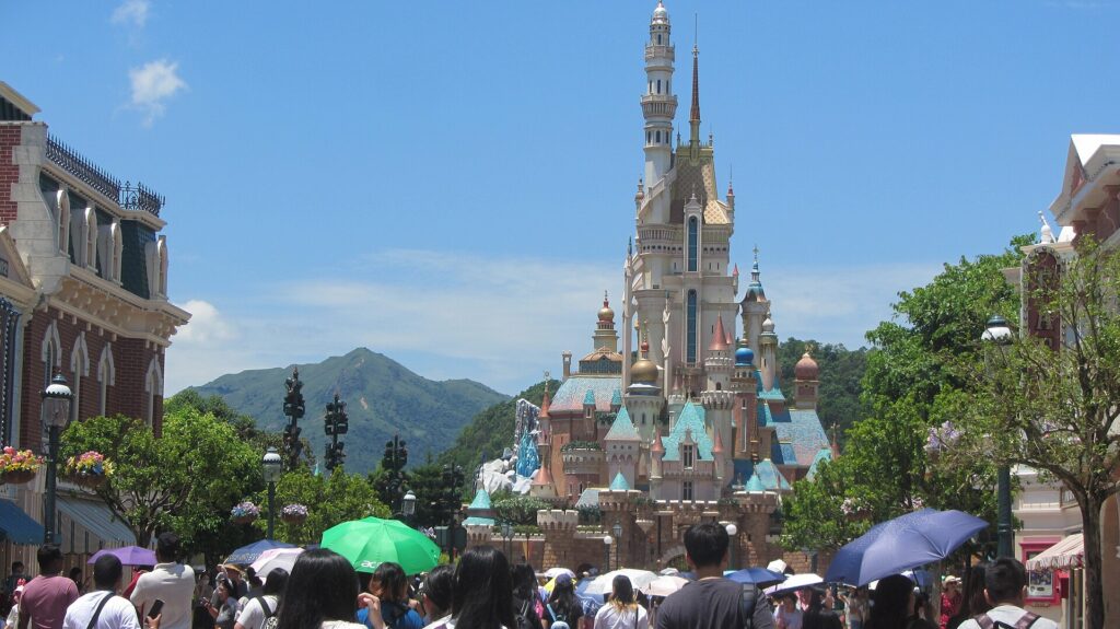 The Castle of Magical Dreams at Hong Kong Disneyland with mountains behind it